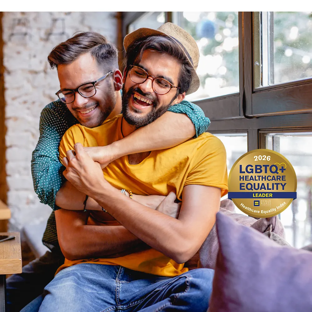 Two men hugging by a window