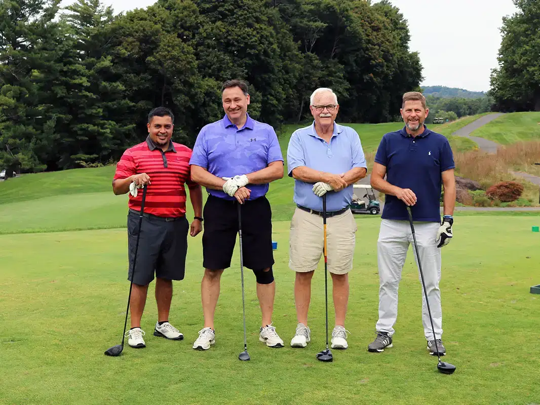 4 Wheeler Golf Classic participants posing for a photo on the golf course