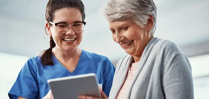 Female Medical Professional + Elderly Patient with iPad (700x333 vertical tab)